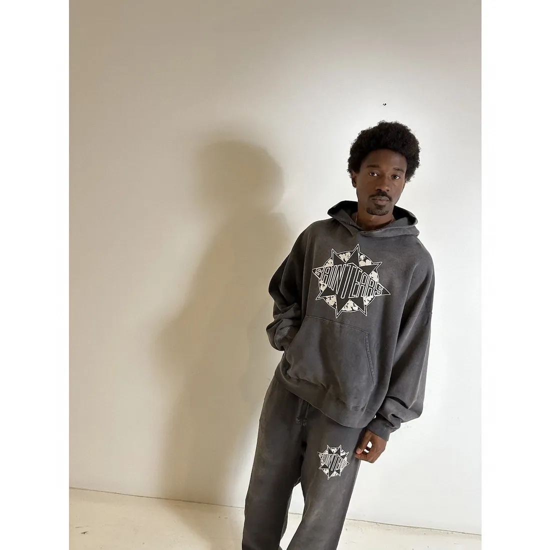 DENIM TEARS x SAINT Mxxxxxx SAINT TEARS Hoodie/BLK Five-pointed star cotton hole-in-the-dark distressed hoodie, washed black S-XL Assute dyeing, whole piece sprayed with horse fade/horse weight, co-branded main mark/cotton wash mark/cherub mark, many hanging holes on the front and rear panels, the original version has the same loose fit